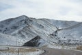 Highway winding past a snowy mountain