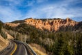 Highway winding toward distant rocks cliffs of southern Utah desert with pink and orange sandstone formations Royalty Free Stock Photo