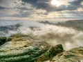 Hiil peaks increased from heavy fog. The first strong sun rays Royalty Free Stock Photo