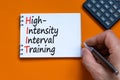 HIIT high-intensity interval training symbol. Concept words HIIT high-intensity interval training on note on a beautiful orange Royalty Free Stock Photo