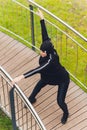 Hijab girl exercising on walkway bridge in early morning. Muslim woman wearing sports clothes doing stretching workout Royalty Free Stock Photo