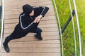 Hijab girl exercising on walkway bridge in early morning. Muslim woman wearing sports clothes doing stretching workout Royalty Free Stock Photo