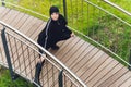 Hijab girl exercising on walkway bridge in early morning. Muslim woman wearing sports clothes doing stretching workout Royalty Free Stock Photo