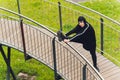 Hijab girl exercising on walkway bridge in early morning. Muslim woman wearing sports clothes doing stretching workout Royalty Free Stock Photo