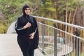 Hijab girl exercising on walkway bridge in early morning. Muslim woman wearing sports clothes doing stretching workout Royalty Free Stock Photo