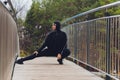 Hijab girl exercising on walkway bridge in early morning. Muslim woman wearing sports clothes doing stretching workout Royalty Free Stock Photo