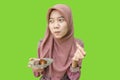 hijab muslim woman eating dates during iftar with green background