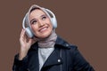 Hijab woman was listening music using wireless headphones with a smiling expression while looking up Royalty Free Stock Photo