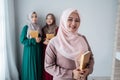 Hijab women smiling hold holy book of Al-quran