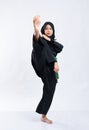 Hijab women wearing pencak silat uniforms with green belts perform forward kicks