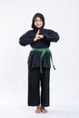 Hijab women wearing pencak silat uniforms with green belts perform hand gestures of respect