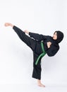 Hijab women wearing pencak silat uniforms with green belts perform high kick movements