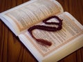 Hijri Islamic New Year concept. Close up prayer from opened holy Quran book with rosary on a wooden background