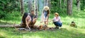 Hike barbecue. Friends enjoy weekend barbecue in forest. Company friends picnic or barbecue roasting food near bonfire Royalty Free Stock Photo