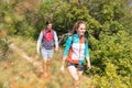 Hike couple in summer outfit and with backpacks walking in a forest Royalty Free Stock Photo