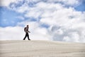 Hike, dunes and male in nature for adventure, walk and desert landscape for travel or exercise. Fitness, holiday and Royalty Free Stock Photo