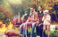 Happy family sitting on bench at camp fire Royalty Free Stock Photo