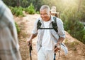 Hike, trekking sticks and senior male walking with friends for fitness and health in nature. Healthy, active and smiling Royalty Free Stock Photo