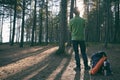 Hiker adventurer man in felt hat with backpack and ÃÂamping gear standing in pine woods at sunset. Adventure, trekking, local Royalty Free Stock Photo