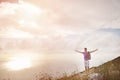 Hiker with arms wide open on top of a mountain - freedom conquest concept