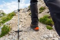 Hiker ascending a mountain and walking path upwards using poles.