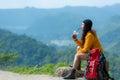 Hiker asian woman sitting and drinking coffee for relax and rest on mountain. Female adventure backpack and trips camping on hike