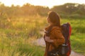 Hiker asian women walking in national park with backpack. Woman tourist going camping in meadow forest,