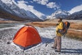 Hiker with backpack at camping in the mountains during springtime.