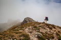 Hiker with backpack going uphill. Hiker going up to the mountain peak on a very steep trail Royalty Free Stock Photo