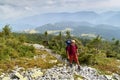 Hiker with backpack going uphill. Hiker going up to the mountain peak on a very steep trail Royalty Free Stock Photo