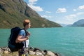 hiker with backpack looking at Gjende lake in Jotunheimen National