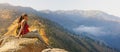 Hiker with backpack relaxing on a rock and enjoying beatiful mountains