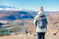 Hiker with backpack relaxing on top of a mountain and enjoying valley view. Royalty Free Stock Photo