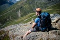 hiker with backpack resting on Besseggen ridge in Jotunheimen National