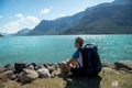 hiker with backpack resting near Gjende lake in Jotunheimen National
