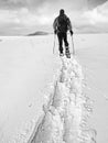 Hiker with backpack snowshoeing in deep drift. Man with walk in hill.