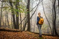 Hiker with backpack standing in autumn woodland