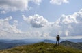 Hiker with backpack standing on a top of a mountain enjoying lookout view of mountains. Nature landscape in Carpathians