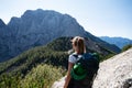 Hiker with a backpack stopping to look at the beautiful view of mountains