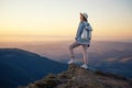 Hiker with backpack in the top of the mountain. Young girl walking in the mountains during sunset. Mountains and people. Royalty Free Stock Photo