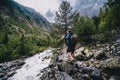 A hiker with backpack, a traveler, walks alone, stepping from boulder to stone. Caucasus mountains, The turbulent flow of the Royalty Free Stock Photo