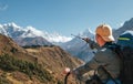 Hiker backpacker man using trekking poles pointing to Everest 8848m mountain during high altitude Acclimatization walk. Everest