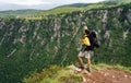 Hiker with backpacks reaches the summit of mountain peak. Success, freedom and happiness concept Royalty Free Stock Photo