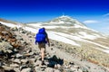 Hiker with big traveling rucksack looking forward on the mountain trail Royalty Free Stock Photo