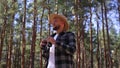 hiker with binoculars looks around while walking into the forest.