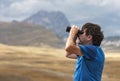 Man scanning the sky with binoculars