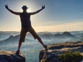 Hiker in black celebrate triumph between two rocky peaks Royalty Free Stock Photo