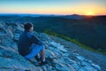 Hiker in black sit alone on summit. Wonderful mountains