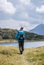 Hiker in boots and with backpack is walking un the upland, Austria