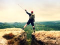 Hiker with broken leg in immobilizer. Tourist with medicine crutch above head achieved peak. Royalty Free Stock Photo